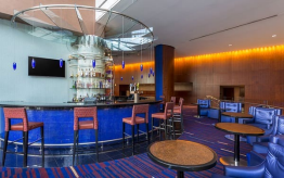Modern bar with blue seating and decor.