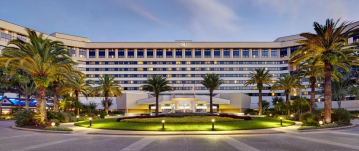 Hotel exterior with palm trees at dusk.