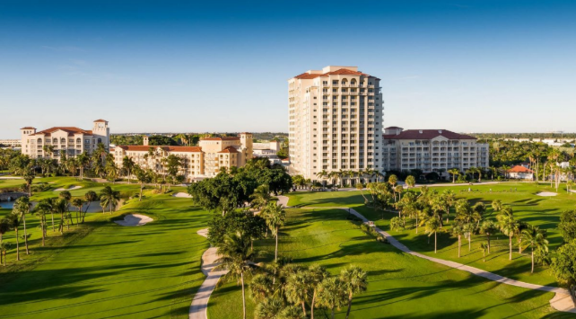 Golf course with tall buildings in background.